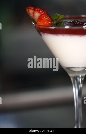 dessert bianco con ganache di fragole dolci con cioccolato e scorza di limone servito in una ciotola di vetro. Foto Stock