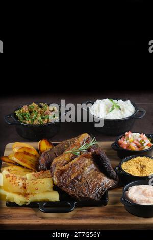 Bistecca grigliata Chuck Eye Roll arrostita su un tagliere. barbecue con insalata di fagioli di riso. vista dall'alto Foto Stock