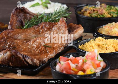 Bistecca grigliata Chuck Eye Roll arrostita su un tagliere. barbecue con insalata di fagioli di riso. vista dall'alto Foto Stock