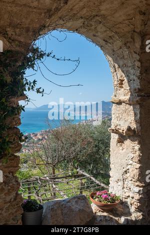 Ammira la Riviera delle Palme da un arco in pietra del portico Roccaro nel borgo medievale di Borgio Verezzi, Savona, Liguria, Italia Foto Stock
