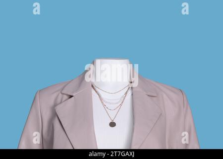 Manichino femminile vestito con t-shirt bianca con collana ed elegante giacca in pelle su sfondo azzurro Foto Stock