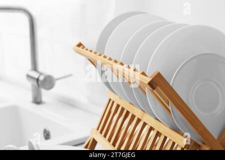 Rack per asciugatura con piatti puliti in cucina, primo piano Foto Stock