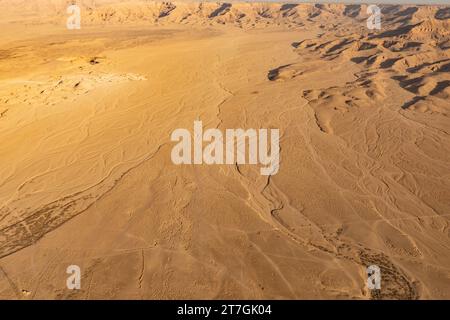 Vista aerea del deserto arido con lavaggi di fiume asciutti intrecciati e montagne erose Foto Stock