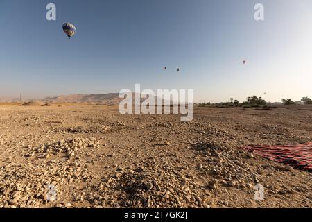 Le mongolfiere sorvolano l'arido paesaggio desertico Foto Stock