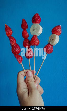 Fragole e banane su spiedini di legno Foto Stock