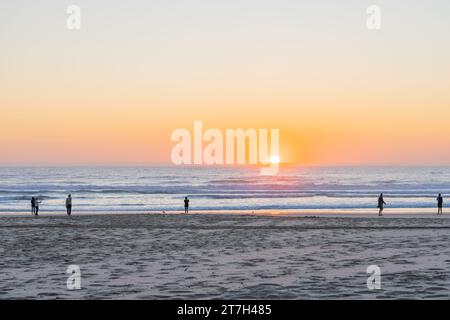 Surfers Paradise - 21 settembre 2023; l'alba sulla spiaggia di Surfers Paradise con persone insignificanti ai bordi delle acque lontane. Foto Stock