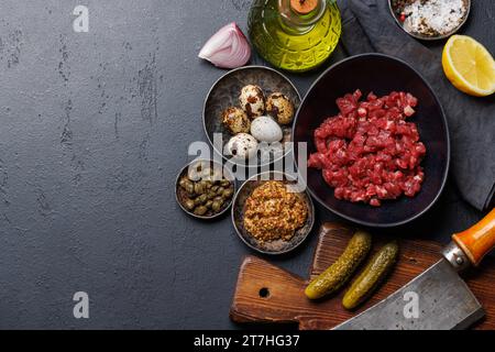 Cottura di una saporita tartare di manzo con cetriolini sottaceto e pane tostato. Base piatta con spazio per la copia Foto Stock
