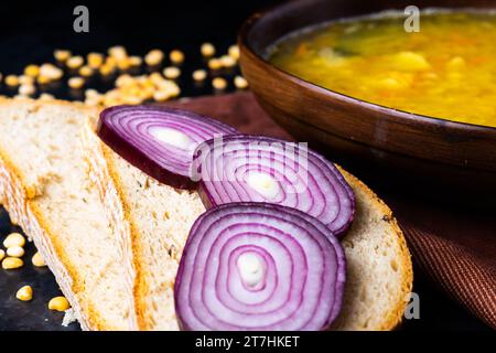 Appetitosa zuppa di piselli caldi e cipolla servita con fette di pane Foto Stock