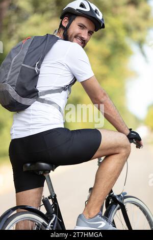 pedalando sulla strada guardando indietro le azioni Foto Stock