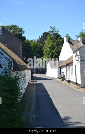 Cultra, County Down, Irlanda del Nord 15 giugno 2014 - Village Street nell'Ulster Folk and Transport Museum con due uomini che chiacchierano sul davanzale Foto Stock