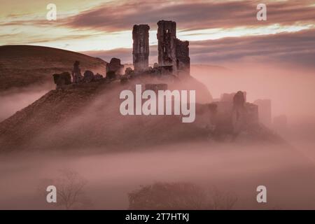 Corfe Castle nel Dorset in una nebbiosa mattinata all'alba Foto Stock