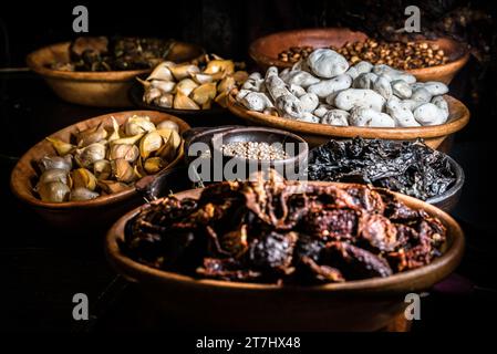 Una vasta gamma di ciotole in legno traboccanti con un assortimento di frutta secca, frutta secca e spezie Foto Stock