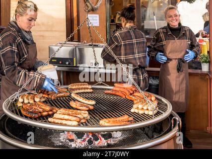 Londra, Regno Unito. Salsicce tedesche cucinate a Trafalgar Square dalla German Sausage Company, nel mercatino di Natale di fronte alla National Gallery, Foto Stock