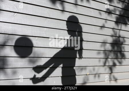 La ragazza adolescente pratica pallavolo tira l'ombra con la palla a mezz'aria con le braccia allungate Foto Stock