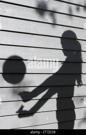 La ragazza adolescente pratica i colpi di pallavolo - ombra con la palla a mezz'aria e braccia allungate Foto Stock