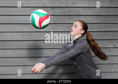 La ragazza adolescente pratica tiri di pallavolo Foto Stock