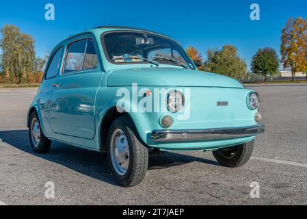 Cuneo, Italia - 15 novembre 2023: Famosa vecchia Fiat 500 cinquecento di colore blu nel parcheggio con sfondo autunnale Foto Stock