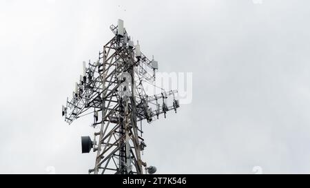 Una vista maestosa di una vecchia torre radio illuminata su un cielo azzurro, perfetta per i concetti del settore della telefonia mobile e della comunicazione Foto Stock