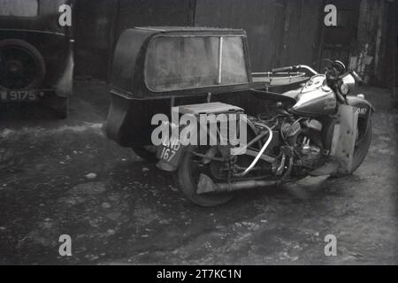 Anni '1950, una moto Harley Davidson con sidecar parcheggiata in un vicolo laterale, Oldham, Inghilterra, Regno Unito. L'auto laterale a una ruota e la motocicletta a due ruote sono un veicolo a tre ruote ed è talvolta noto come combinazione, outfit o carro. Foto Stock