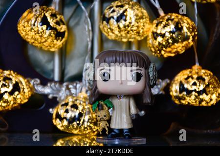 Funko Pop action figure di Hermione Granger con mandrake del film Harry Potter. Luci di zucca di Halloween, palazzo buio, magia, stagione spettrale. Foto Stock