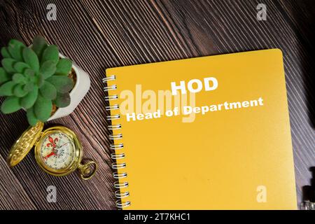 Concetto di HOD - il capo dipartimento scrive su un libro isolato su un tavolo di legno. Foto Stock