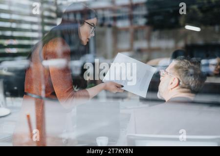 Il team aziendale multi-generazionale collabora alla pianificazione strategica e all'analisi di mercato in un moderno ufficio aziendale per una crescita sostenibile dei profitti. Foto Stock