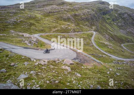 Motociclista vicino alla cima del passo di Bealach na Bà vicino ad Applecross, Scozia Foto Stock