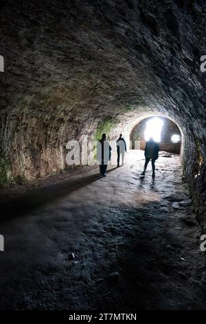 Tre persone si trovano nella volta dei Whigs ad arco, dove 167 Covenanter sono stati imprigionati e torturati per 9 settimane nel 1685, Dunnottar, Scozia, Regno Unito, Europa Foto Stock