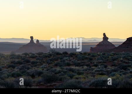 Luce dell'alba dietro Rooster Butte, che ambienta Hen Butte e Franklin Butte nella Valley of the Gods, Bears Ears National Monument, Utah. Foto Stock