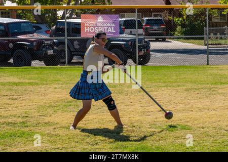 Una concorrente femminile in kilt fa oscillare il martello nelle Highland Games al Moab Celtic Festival, Scots on the Rocks, a Moab, Utah. Foto Stock