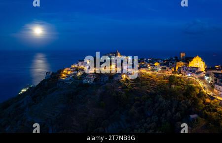 Luna piena piena piena nuvolosa nel cielo scuro illuminante di notte - vista aerea di forza D'Agro, storica città siciliana sulla roccia sul mare ionico. Italia Foto Stock