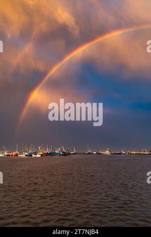 Bellissimo doppio arcobaleno sul mare e sulla costa, pieno di piccole barche private subito dopo la tempesta e la pioggia al bellissimo tramonto nuvoloso all'ora d'oro Foto Stock