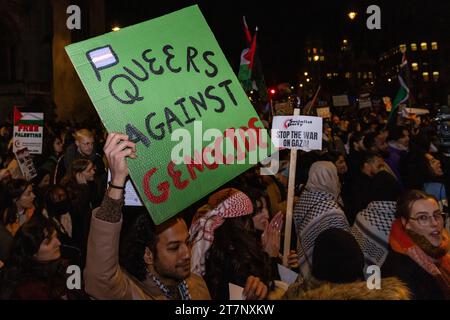 Londra, Regno Unito. 15 novembre 2023. Un manifestante pro-palestinese tiene un cartello con la scritta "Queers Against Genocide” in occasione di un raduno di emergenza per la Palestina fuori dal Parlamento in occasione di un voto alla camera dei comuni per chiedere o meno un cessate il fuoco a Gaza. Il raduno è stato organizzato da Palestine Solidarity Campaign (PSC), Stop the War Coalition, Friends of al-Aqsa, Muslim Association of Britain, Palestinian Forum in Britain e CND. Crediti: Mark Kerrison/Alamy Live News Foto Stock