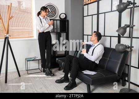 Agenti dell'FBI che bevono caffè in ufficio Foto Stock