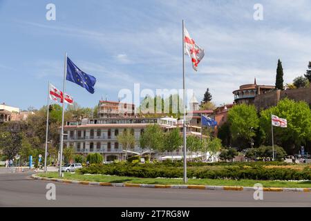 Tbilisi, Georgia - 29 aprile 2019: Bandiere dell'Unione europea e della Georgia montate a Tbilisi Europe Square, foto di una strada scattata in una giornata di sole Foto Stock