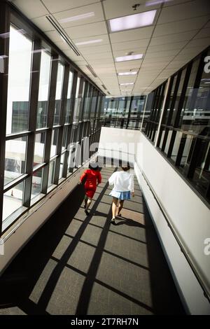 Una donna non identificata con equipaggio ha raggiunto il cancello d'imbarco dopo un'ultima chiamata a bordo presso un terminal aeroportuale in vacanza. Foto Stock