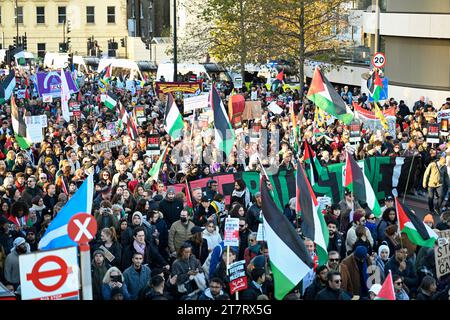 I manifestanti sventolano striscioni e bandiere in una marcia per la Palestina nel centro di Londra. Marcia nazionale per la Palestina 11 novembre 2023 Foto Stock