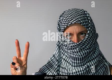 Donna dagli occhi verdi che indossa una sciarpa palestinese. Concetto di conflitto Foto Stock