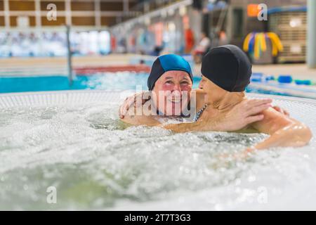 Coppia anziana che si abbraccia insieme in piscina e si rilassa. Foto di alta qualità Foto Stock