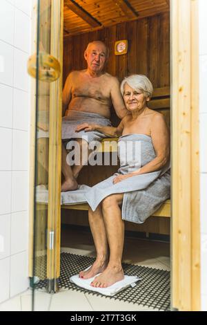 Persone anziane che sudano nella sauna dell'hotel durante le vacanze, foto verticale completa. Foto di alta qualità Foto Stock