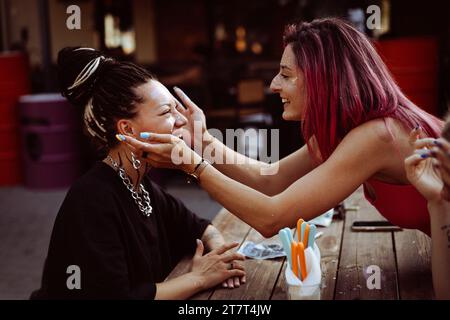 Le donne amiche si divertono e si spalmano le stelle a vicenda. Foto Stock