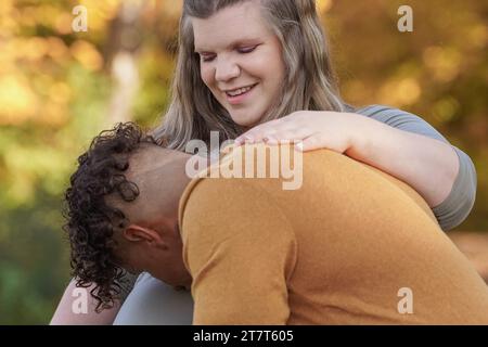 uomo che bacia una pancia femminile in gravidanza in autunno Foto Stock