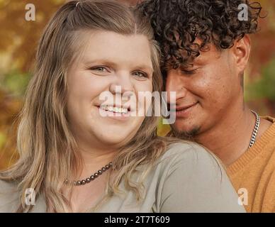 Primo piano di una donna che guarda la macchina fotografica, uomo che sbatte di lato Foto Stock
