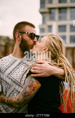 Una giovane coppia innamorata abbraccia e baci. Foto Stock