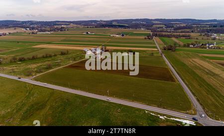 Un paesaggio di droni di campagna Amish con terreni agricoli, fattorie e Rolling Hills in un giorno d'inverno Foto Stock