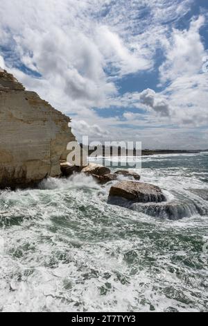 Scogliere bianche di gesso e surf martellante lungo la costa mediterranea a Rosh HaNikra, al confine con il Libano nel nord di Israele. Foto Stock