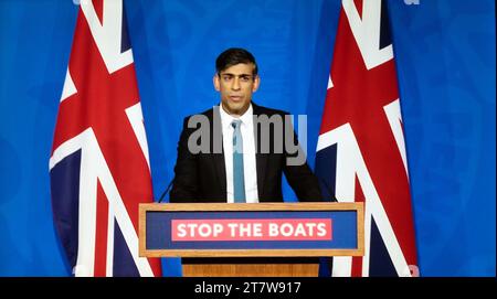 Il primo Ministro Rishi Sunak in piedi sul podio con il cartello Stop the Boats affiancato dalle bandiere Union Jack che parlano il 15 novembre 2023 Londra Regno Unito Foto Stock