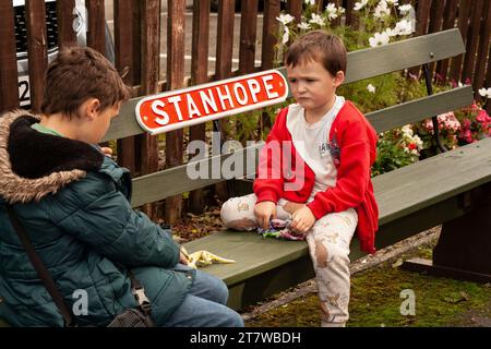 Anticipazione della Heritage Railway: Due giovani fratelli di 6 e 12 anni attendono con ansia il loro treno a Stanhope, contea di Durham. Impegnato nel gioco Foto Stock