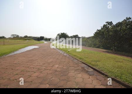 irrigatore. Irrigatore per prati che spruzza acqua sull'erba verde. Sistema di irrigazione. Sentiero in pietra per passeggiate. Grandangolo per il Brasile. Brasile Foto Stock