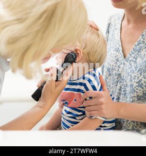 Bambino bambino bambino bambino in esame dal suo medico pediatra durante un controllo medico standard in presenza e comfort di sua madre. Sanità pubblica nazionale e cura dei bambini koncept Foto Stock